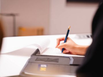 Close up of a student using an Opportunity Hub pen to take notes.